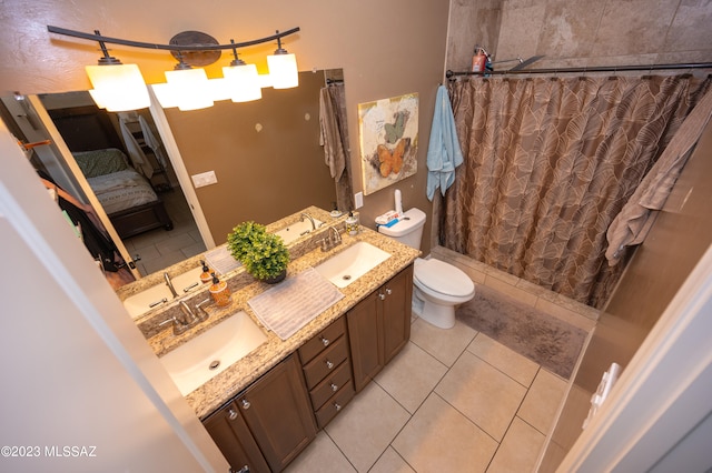 bathroom featuring toilet, tile patterned flooring, and double sink vanity