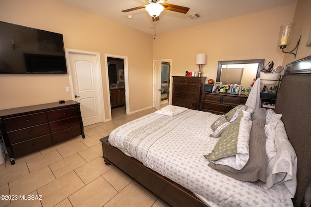 bedroom featuring light tile patterned flooring, connected bathroom, and ceiling fan