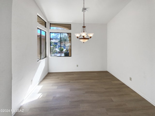 unfurnished dining area featuring dark hardwood / wood-style flooring and a chandelier