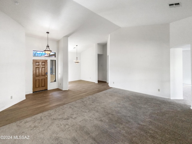 unfurnished living room featuring dark hardwood / wood-style flooring and vaulted ceiling