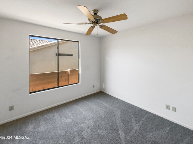 unfurnished room with ceiling fan and carpet