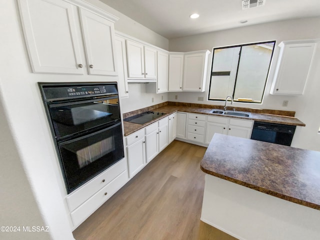 kitchen featuring black appliances, light hardwood / wood-style floors, white cabinetry, and sink