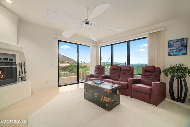 living room with a large fireplace and ceiling fan