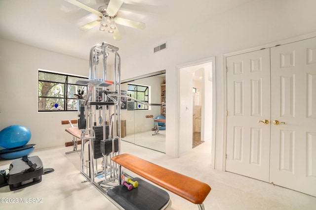 workout room with ceiling fan and light colored carpet