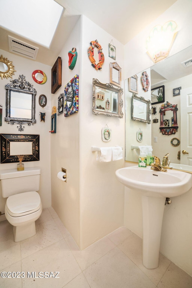 bathroom featuring a wall mounted air conditioner, tile patterned flooring, and toilet