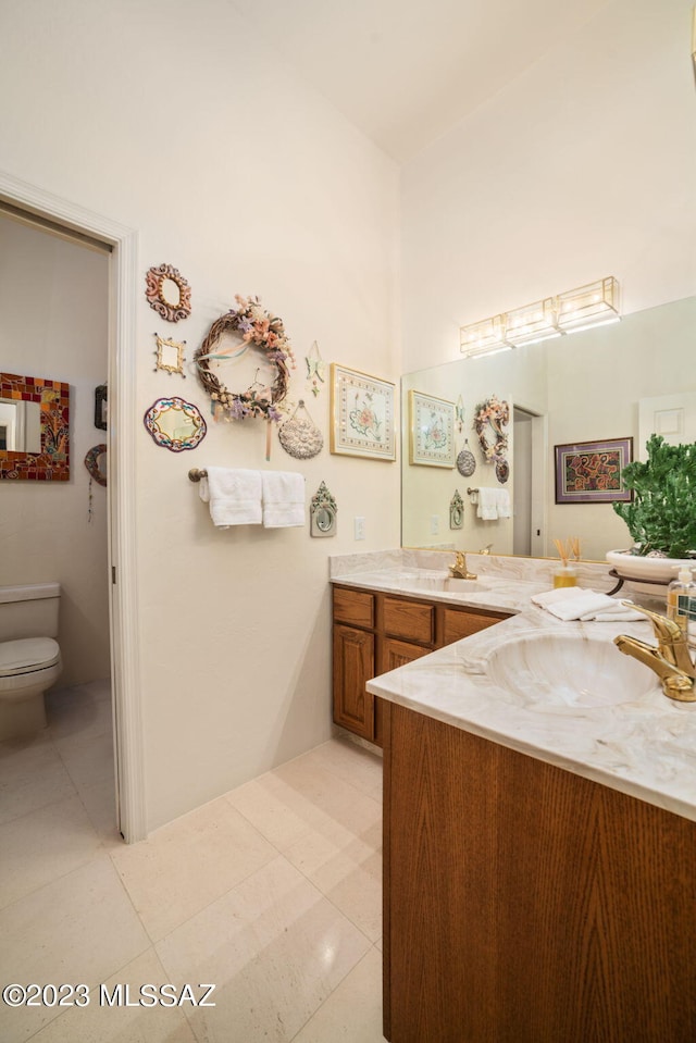 bathroom featuring tile patterned flooring, vanity, and toilet