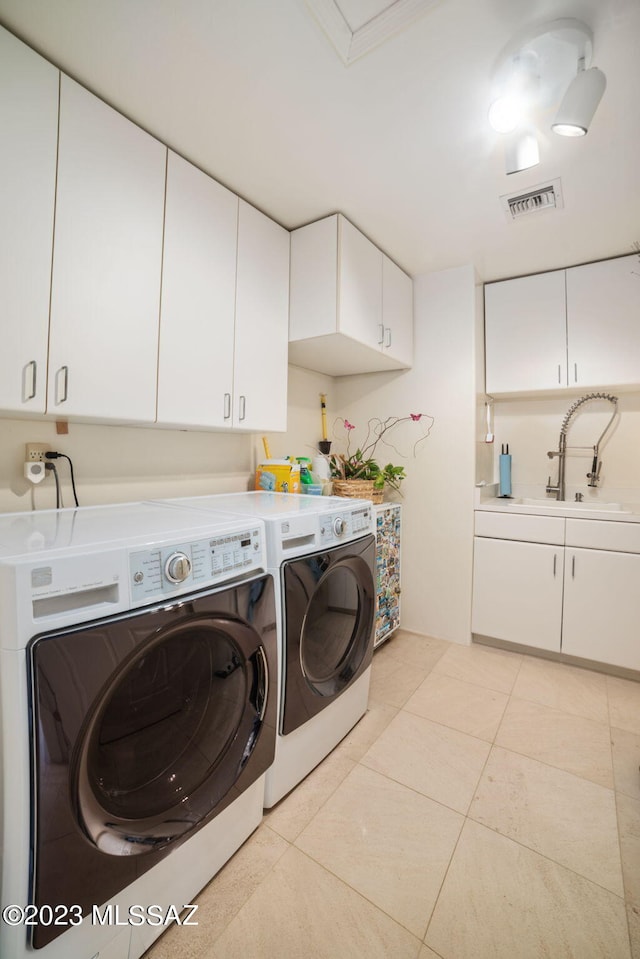 clothes washing area featuring cabinets, washing machine and dryer, light tile patterned floors, and sink