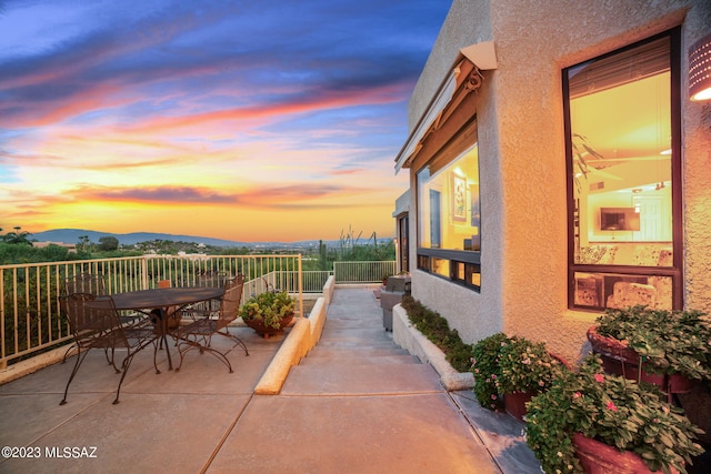 patio terrace at dusk featuring a mountain view