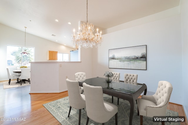 dining room featuring light hardwood / wood-style floors, vaulted ceiling, and a notable chandelier