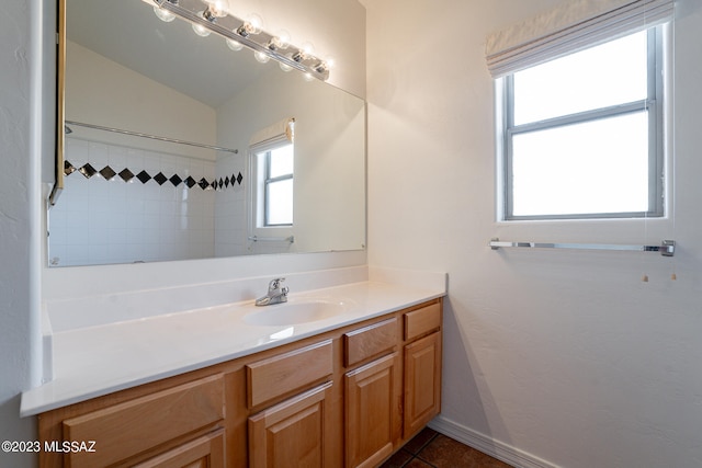 bathroom with a tile shower, tile patterned floors, and vanity