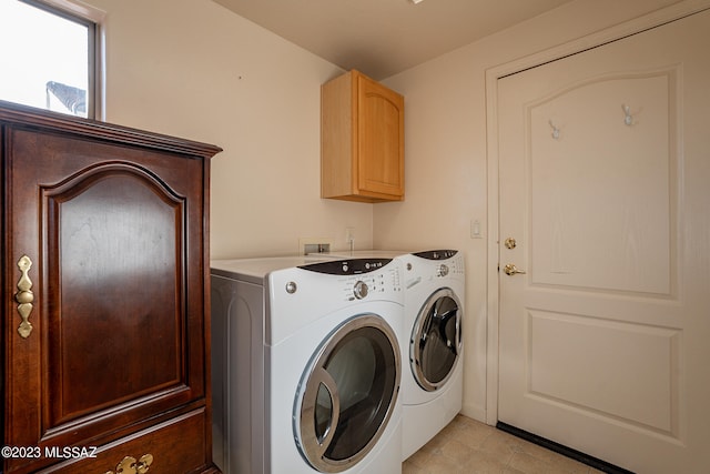 clothes washing area featuring cabinets and washing machine and dryer