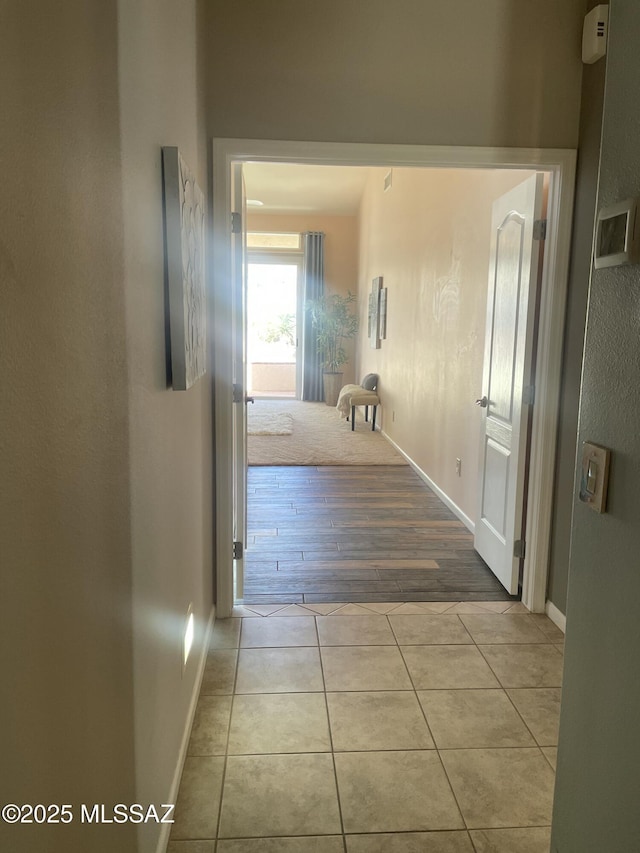 corridor with tile patterned flooring and baseboards