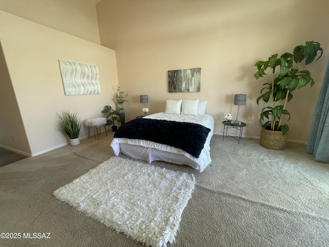 carpeted bedroom featuring baseboards and a towering ceiling