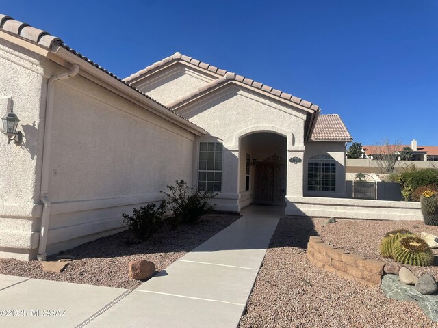 view of front of home featuring concrete driveway, an attached garage, a tile roof, and stucco siding