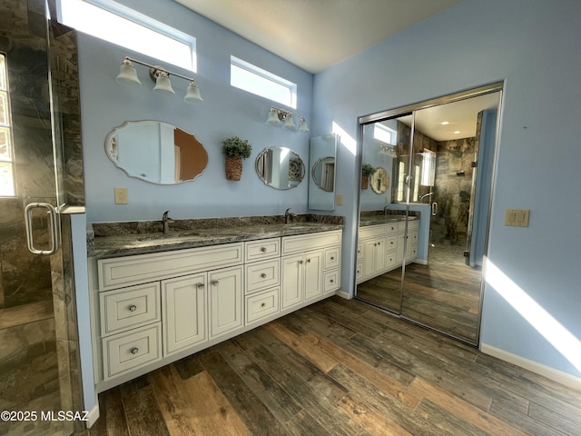 bathroom featuring an enclosed shower, vanity, and wood-type flooring