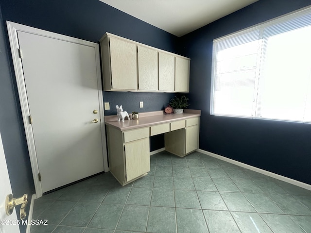 kitchen with light tile patterned floors, light countertops, and baseboards