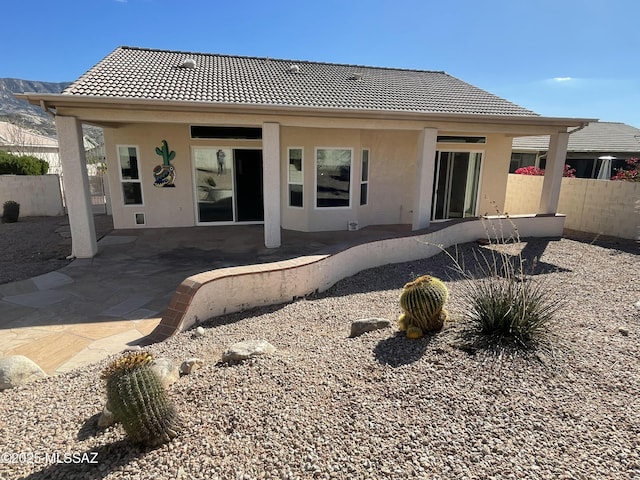 back of property featuring stucco siding, a patio, and fence