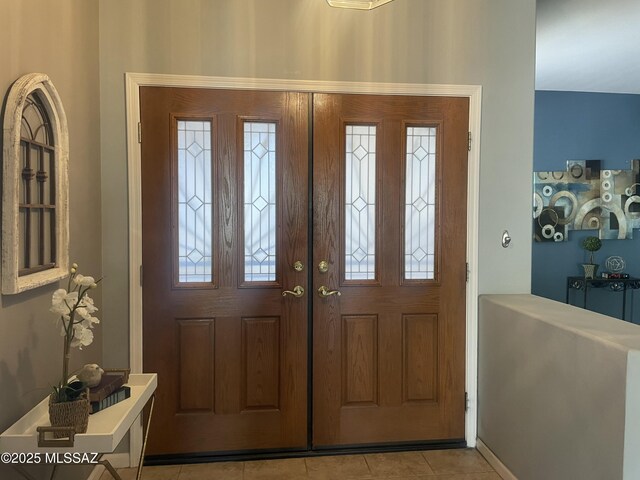 tiled entryway with an inviting chandelier