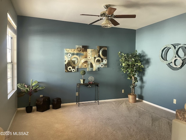 misc room with baseboards, carpet floors, and a ceiling fan