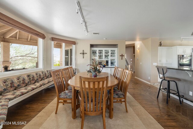 dining area featuring wood-type flooring and rail lighting