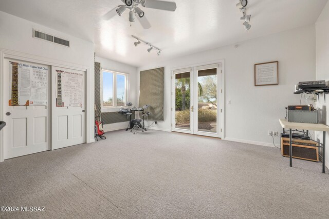 interior space featuring carpet flooring, track lighting, and ceiling fan