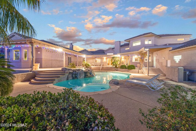 pool at dusk featuring a patio