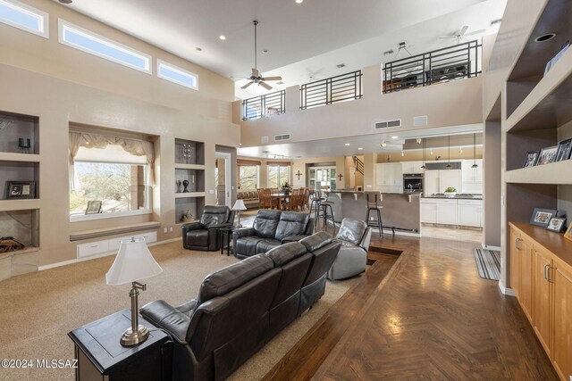 living room with a towering ceiling, a wealth of natural light, and parquet floors