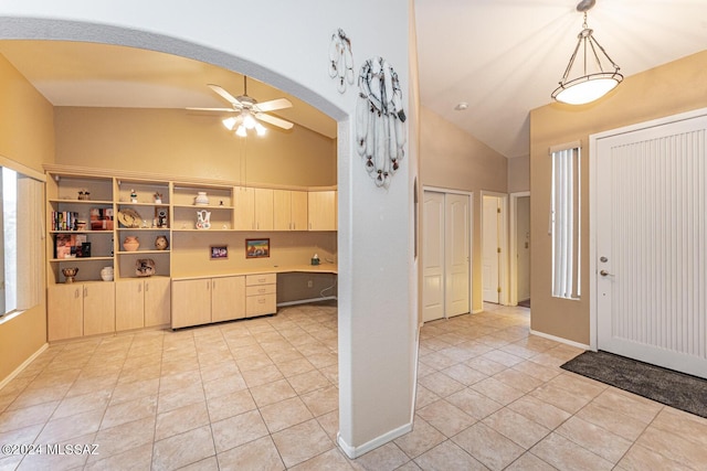 kitchen featuring pendant lighting, lofted ceiling, ceiling fan, built in desk, and light tile patterned floors