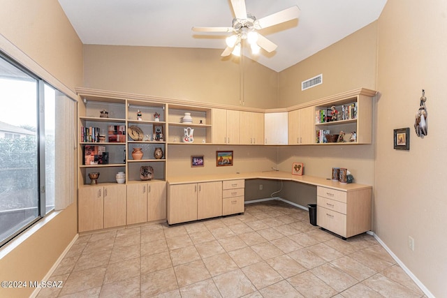 home office featuring built in desk, vaulted ceiling, ceiling fan, and a healthy amount of sunlight