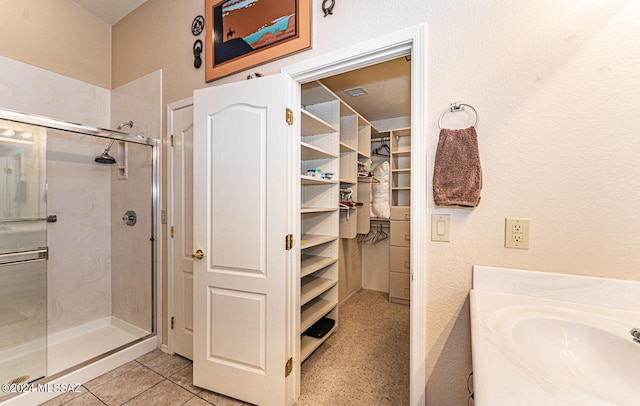 bathroom with sink and a shower with door