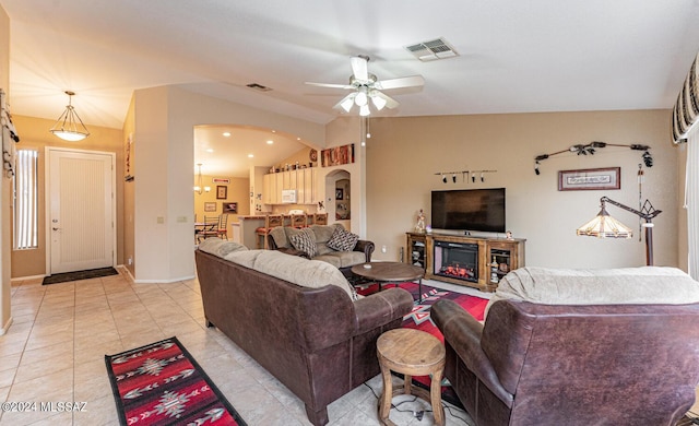 living room featuring ceiling fan, light tile patterned floors, and lofted ceiling