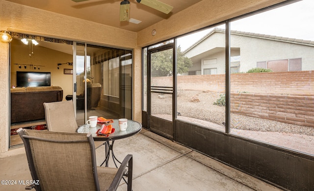 sunroom with ceiling fan and vaulted ceiling