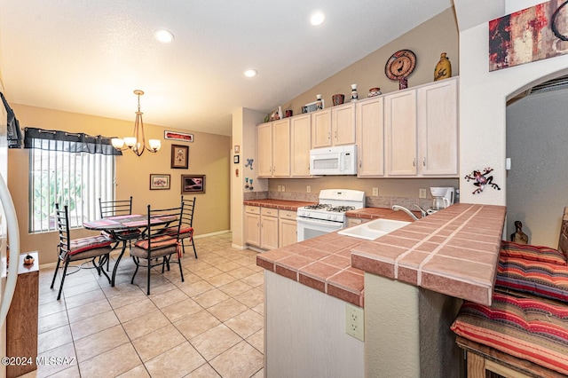 kitchen with kitchen peninsula, white appliances, sink, an inviting chandelier, and hanging light fixtures