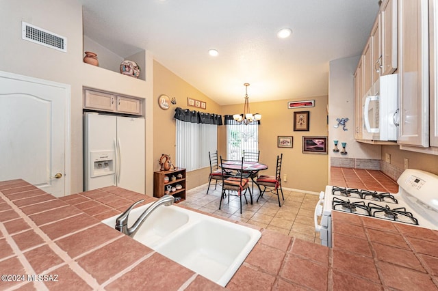 kitchen featuring white appliances, vaulted ceiling, sink, an inviting chandelier, and hanging light fixtures