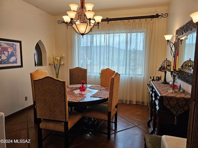 tiled dining room with a chandelier