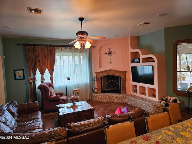 tiled living room featuring built in shelves and ceiling fan