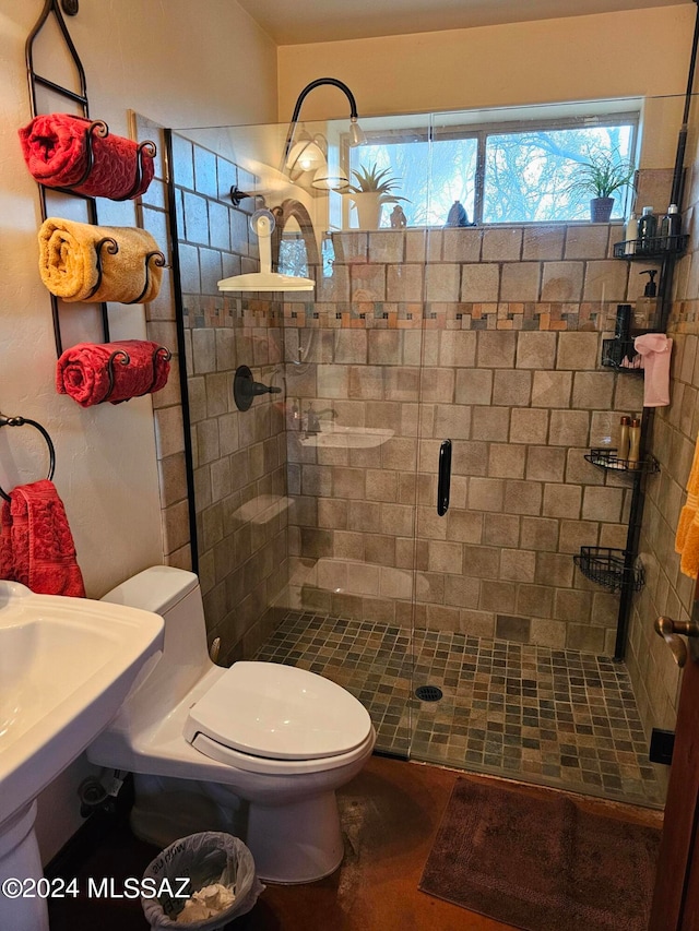 bathroom featuring a shower with door and toilet