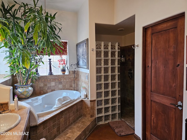 bathroom featuring tile floors, independent shower and bath, and vanity