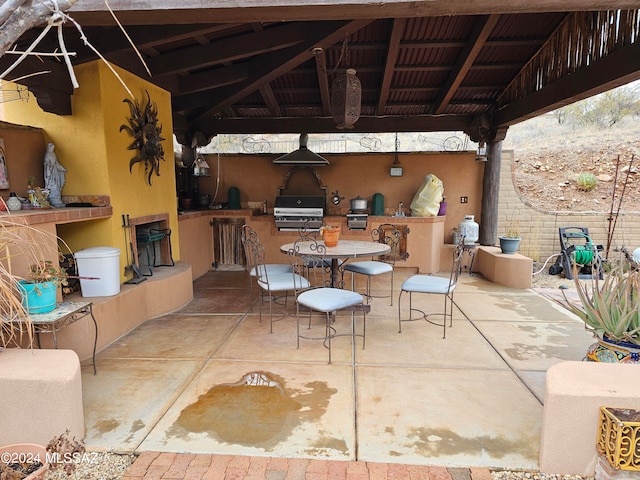 view of patio with a gazebo, a bar, an outdoor kitchen, and area for grilling