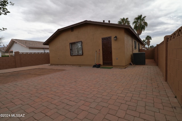 rear view of house with central air condition unit and a patio