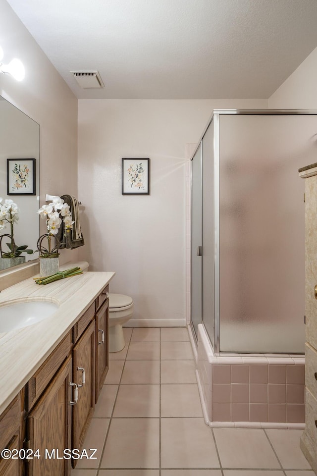 bathroom featuring vanity, an enclosed shower, tile patterned floors, and toilet