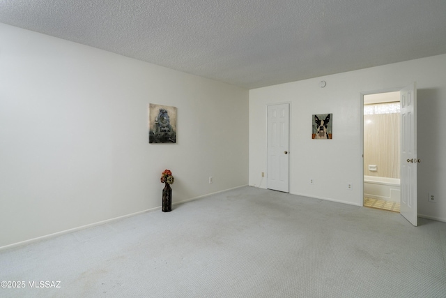 carpeted empty room with a textured ceiling