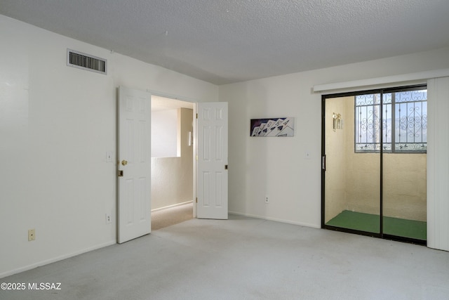 carpeted spare room with a textured ceiling