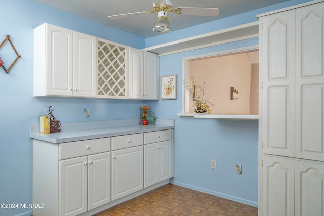 kitchen featuring light parquet flooring, ceiling fan, and white cabinetry