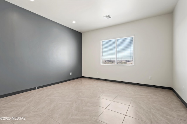 unfurnished room featuring baseboards, visible vents, and recessed lighting