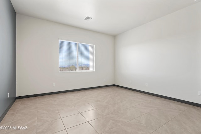 unfurnished room featuring light tile patterned floors, baseboards, and visible vents