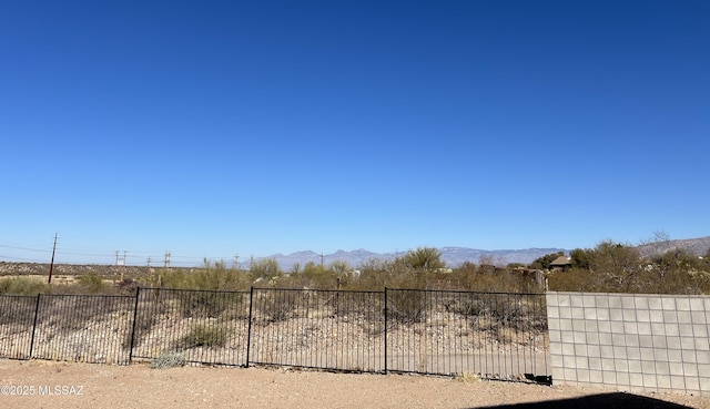 view of yard featuring fence and a mountain view