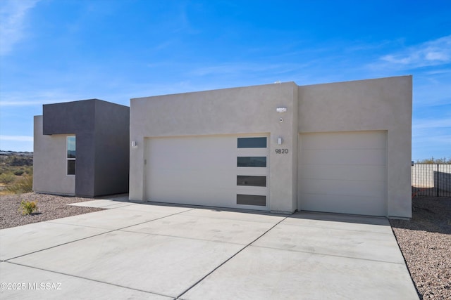 view of front facade featuring a garage, concrete driveway, and stucco siding