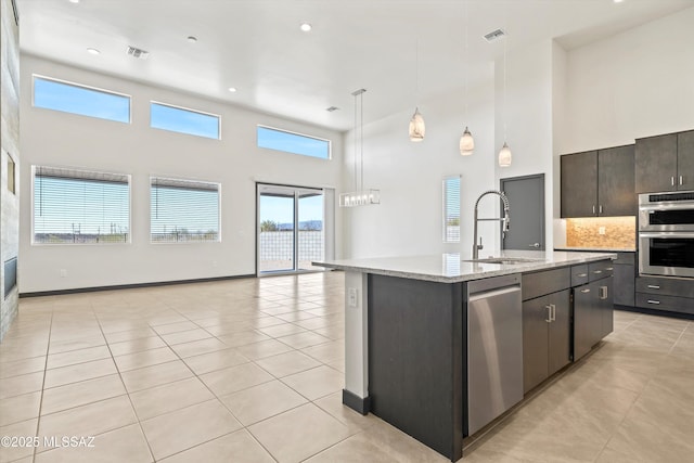 kitchen with visible vents, appliances with stainless steel finishes, open floor plan, a sink, and light tile patterned flooring