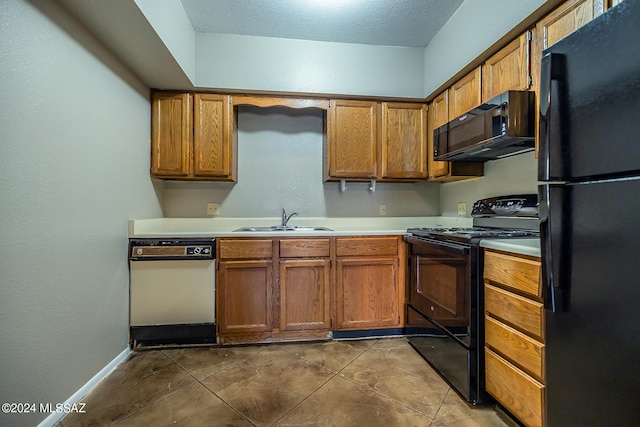 kitchen featuring black appliances, a textured ceiling, sink, and tile patterned floors